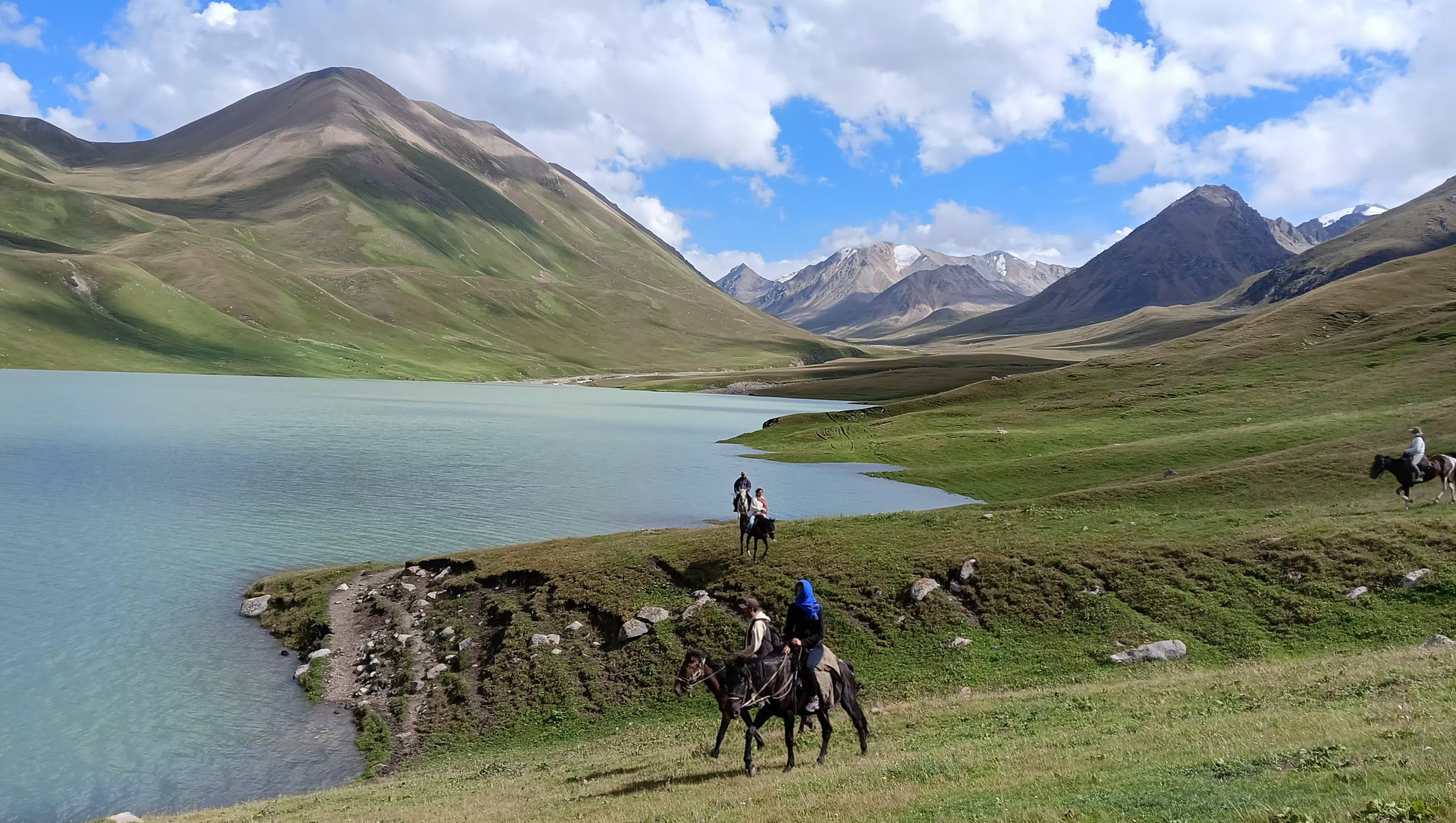 Horse back riders crossing a mountain pass in Kyrgyzstan on a nomad trail