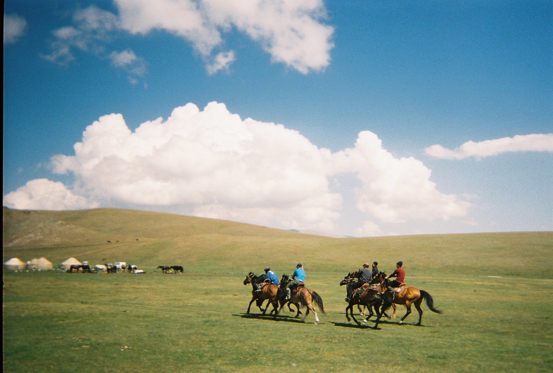 Riders crossing the steppe in Kyrgyzstan