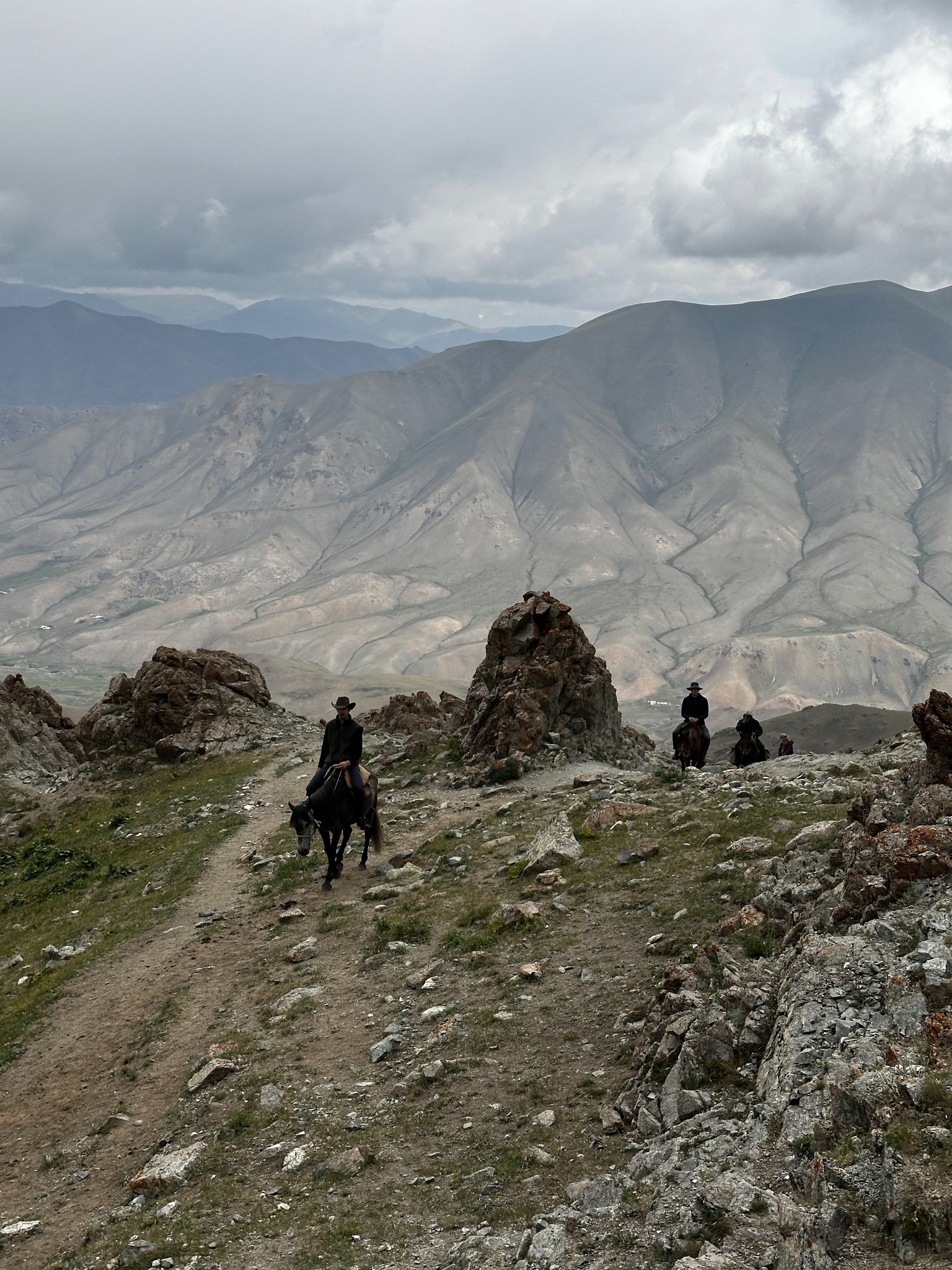 Travelers riding horses across high mountain passes